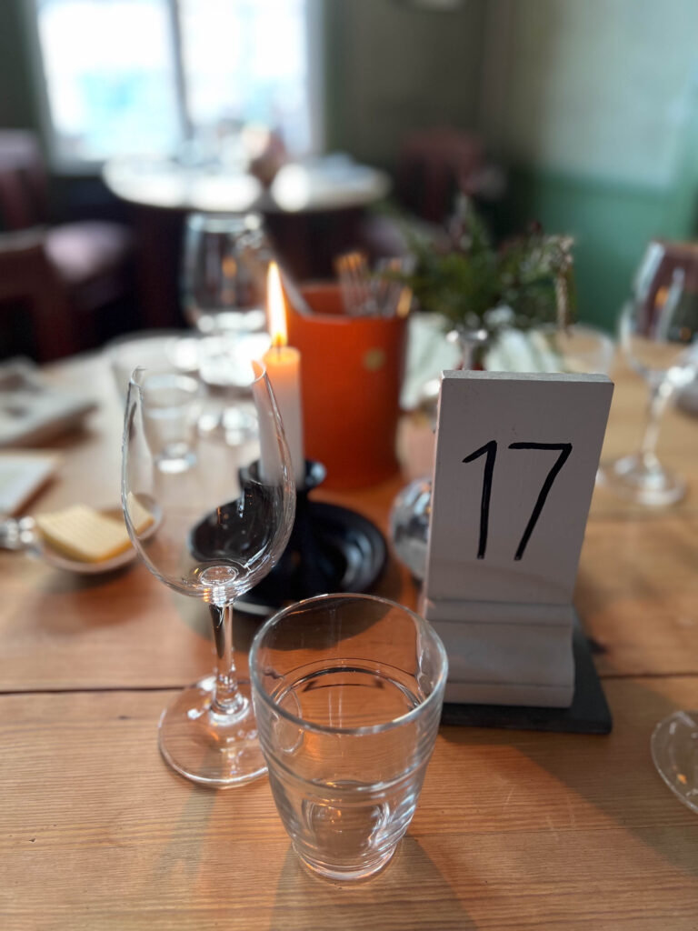 a table with the number 17 on it with glasses and cutleries on top