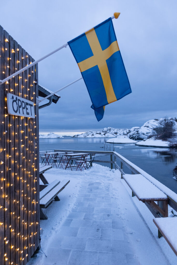 et svensk flagg og julelys utenfor lottas bak och form med et skilt som viser at det er åpent