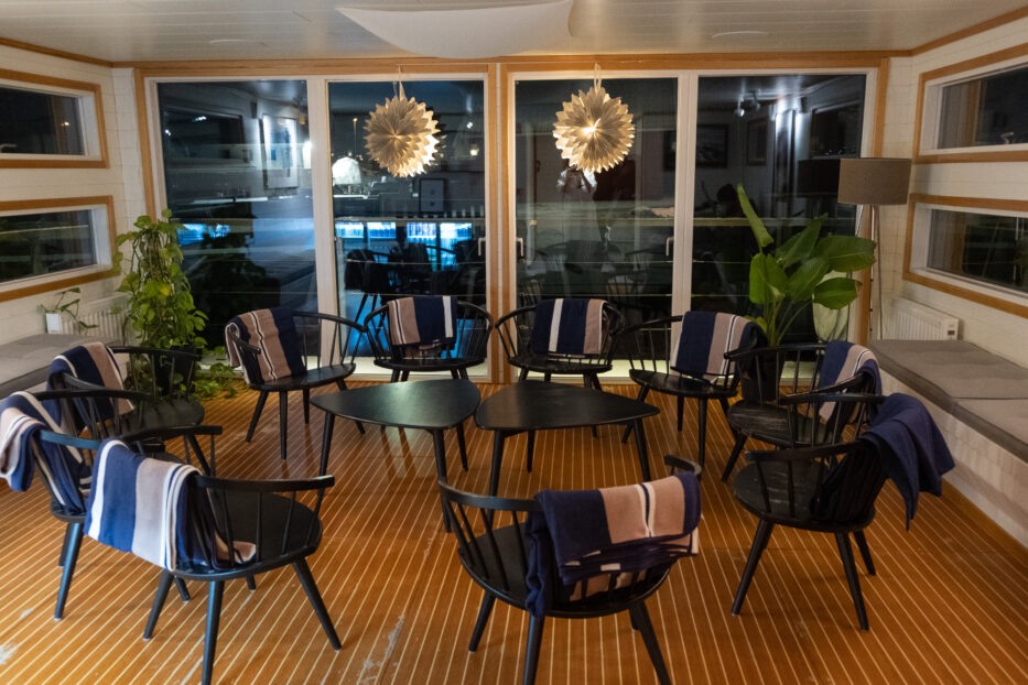 the social hangout area inside the sauna catamaran at salt och sill, chairs and tables in a circle